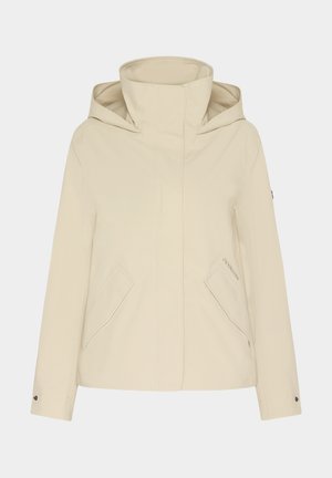 Beige waterdichte jas met hoge kraag, grote voorzakken en een verborgen capuchon. Bevat minimale stiksels en merkdetails aan de zijkant.