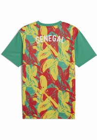 Jersey de manga corta en teal, con un vibrante patrón de hojas en rojo y amarillo. Texto blanco "SENEGAL" en la parte superior de la espalda.