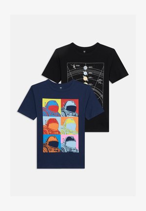 To t-shirts med kortærmet rumtema; én navy med seks farverige illustrationer af astronaut- hjelme, én sort med solsystem- og rumfartøjsdiagram.