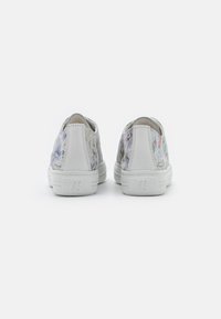 Slip-On-Sneaker mit einer weißen Gummisohle, die ein mehrfarbiges Blumenmuster auf einem hellgrauen Hintergrund und weißen Akzenten aufweisen.