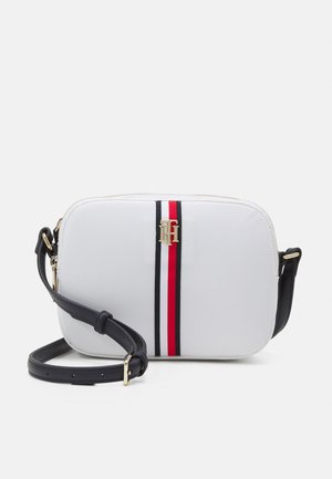 Petit sac bandoulière rectangulaire blanc avec sangle noire réglable, rayures verticales rouges, blanches et noires sur le devant, et détail logo doré.