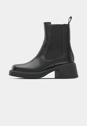 Mustad nahast ankle boots elastsete külgpaneelidega, ümar varvas ja paks plokk kõrgus. Sile tekstuur ja minimalistlik disain.
