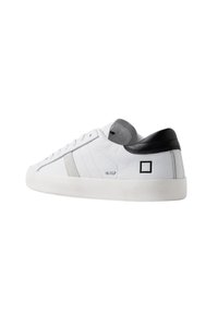 Sneaker bianco in pelle con una striscia di accento grigia, tallone nero e superficie testurizzata. Presenta un logo sul lato e una suola in gomma bianca.