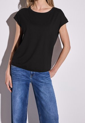 Zwart kort mouwtopje met een ronde hals, lichtgewicht stof, gecombineerd met lichtblauwe wijduitlopende jeans. Soepele textuur, eenvoudig ontwerp.