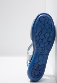 Sandale bleu clair avec une semelle texturée à motif alvéolé, dessus en daim gris et bride réglable pour un ajustement sécurisé. Taille 38.