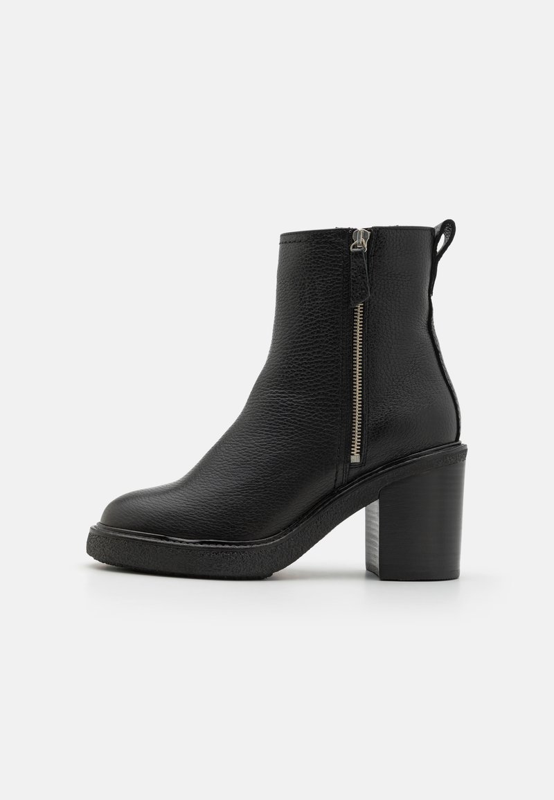 Botas de cuero negras hasta el tobillo con un acabado texturizado, que cuentan con una cremallera lateral, una punta redonda y un tacón grueso.