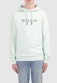 Mintgroene hoodie van zachte stof, met een voorzak in kangoeroestijl, trekkoorden en "BALLIN"-tekst in textuur borduurwerk.