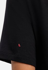 Zwart T-shirt met korte mouwen, een gladde textuur en een klein roze 'L'-label op de linkermouw. Simpel, klassiek ontwerp.