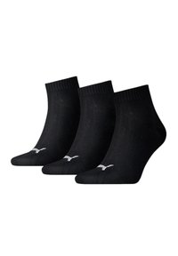 Calcetines de algodón negros hasta el tobillo, paquete de tres, con parte superior acanalada y acentos en blanco del logo a los lados. Textura suave con diseño ligero.