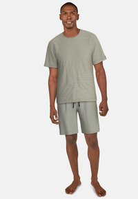 Ljusgrå randig t-shirt med korta ärmar, kombinerad med matchande grå shorts. Tyget verkar mjukt och avslappnat, med dragsko-detaljer.
