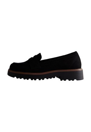 Mocassins en daim noir avec un bout arrondi, un design classique, des détails cousus, et une semelle en caoutchouc robuste avec un petit talon.