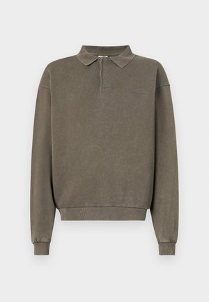 Sweatshirt polo de culoare verde măsliniu, cu fermoar pe un sfert, mâneci lungi, manșete ribbate și o croială lejeră. Fabricat dintr-un material moale, texturat.