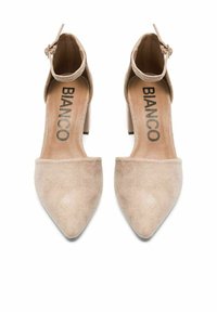 Zapatos de ante beige con tacón cuadrado, puntera puntiaguda y correa en el tobillo. El interior presenta el nombre de la marca "BIANCO" impreso en negro.
