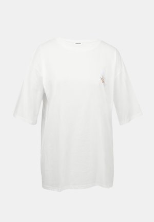 T-shirt de algodão branco com mangas curtas, decote redondo e um pequeno desenho bordado de um pássaro no lado esquerdo do peito.