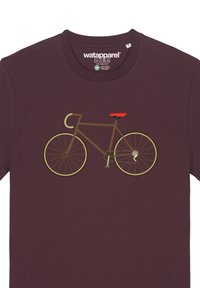 Bordeaux t-shirt met een grafisch ontwerp van een bruine fiets met een rode zitting, gouden accenten en gedetailleerde wielen, die eenvoudige, platte designelementen uitstraalt.