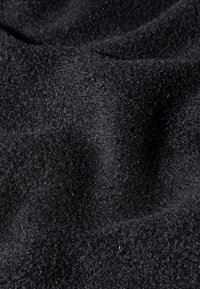 Tessuto nero, strutturato, con una superficie morbida e pelosa, che presenta una trama fine e uniforme e una leggera lucentezza, adatto a diverse applicazioni.