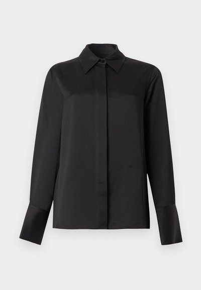 Μαύρο πουκάμισο με μακριά μανίκια και κουμπιά, με κλασικό γιακά και κρυφά κουμπιά, σε ένα απλό ανοιχτό φόντο.