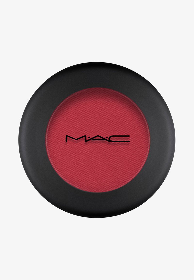 Poudre blush rouge dans un compact noir avec finition mate. Présente une surface texturée et un logo au centre.