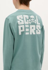 Koszula z długim rękawem w kolorze teal uszyta z bawełny, z dużym, przestarzałym białym napisem "SCOLPERS" oraz czaszką z kośćmi na plecach.
