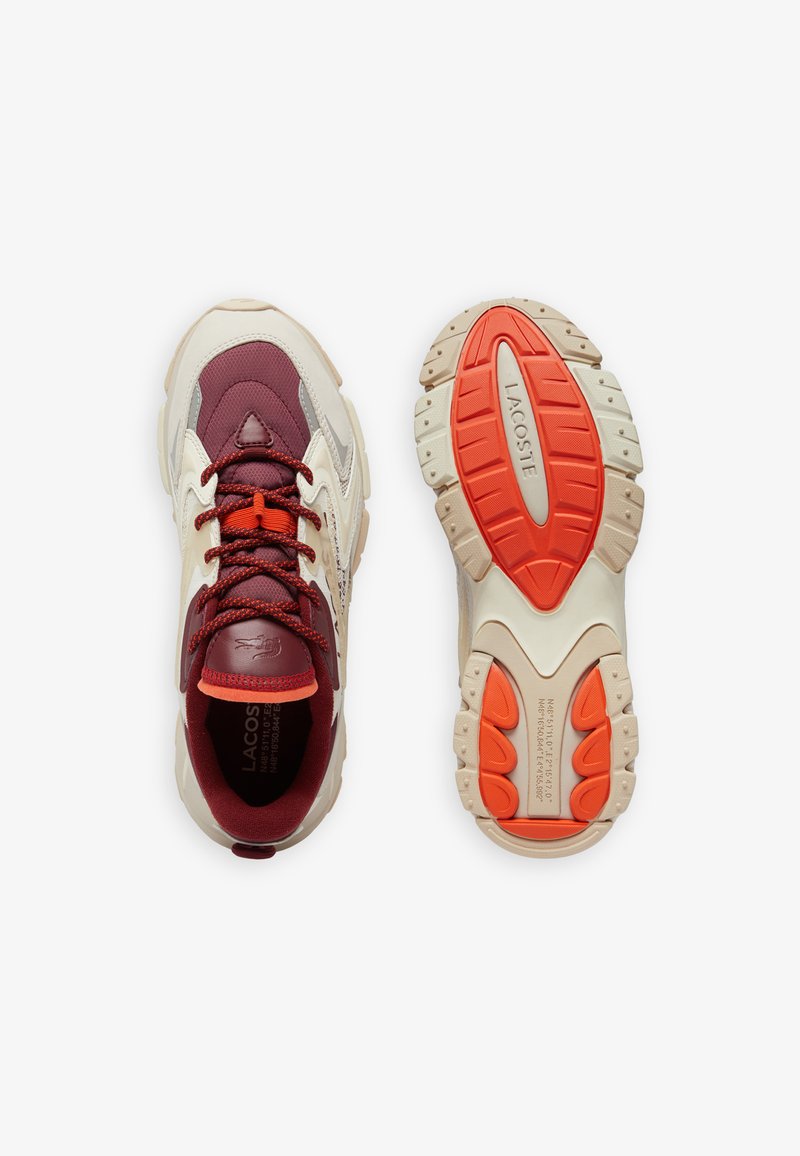 Sneakers Lacoste con tomaia bordeaux e crema, dettagli testurizzati, lacci arancioni e suola in gomma con un motivo battistrada distintivo.