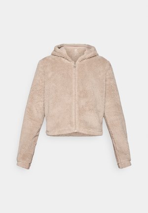 Giacca cropped con cappuccio in morbido beige, caratterizzata da una chiusura a zip, texture pelosa e maniche lunghe per calore e comfort.