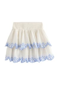 Hvid lagdelt nederdel med en smocked talje, der har blå blomsterbroderi langs de scalloperede kanter af flæserne.