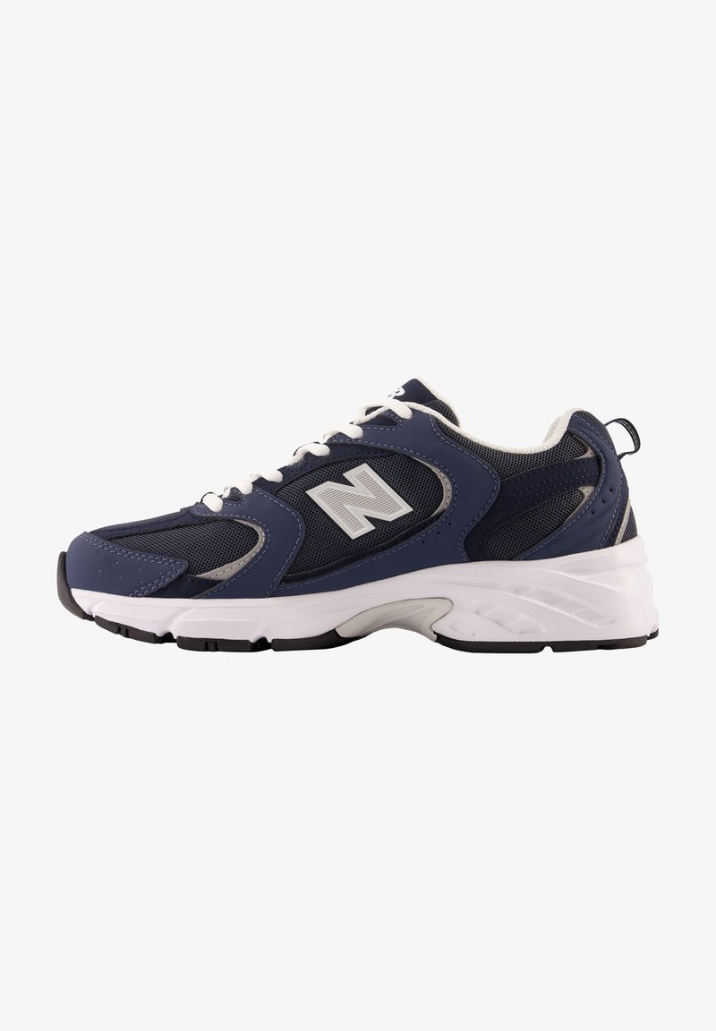 Baskets de sport bleu marine et noir avec semelle et lacets blancs, panneaux en mesh et grand logo "N" sur le côté.