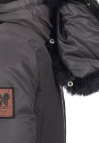 Grau isolierte Jacke mit Kunstfellbesatz an der Kapuze, ausgestattet mit einem braunen Logopatch und silbernen Knopfdetails an der Vorderseite.