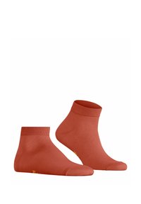 Chaussettes de cheville en coton couleur rouille avec des bords côtelés et un petit logo jaune près des orteils. Texture lisse et design ajusté.