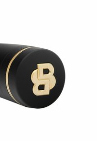 Crni cilindrični poklopac proizvoda s zlatnim akcentima. Ima istaknut zlatni logo "BB". Glatka mat tekstura s tankim zlatnim pojasom.