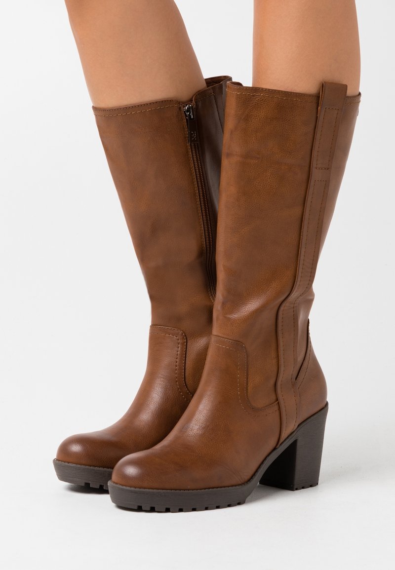 Bottes marron jusqu'au genou en similicuir, dotées d'une fermeture éclair latérale, d'un talon bloc, d'une surface texturée et de détails décoratifs de couture.