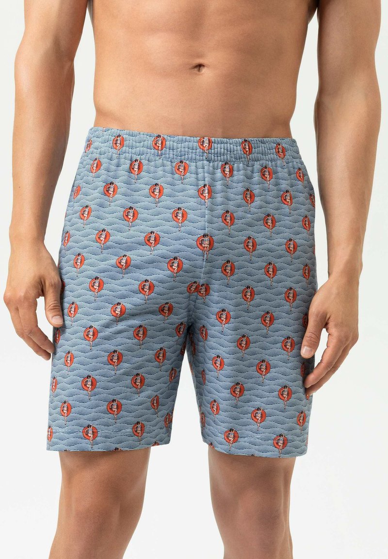Blaue gemusterte Boxershorts mit Wellenmuster und roten/schwarzen grafischen Akzenten. Elastischer Bund sichtbar; Stoff wirkt weich und strukturiert.