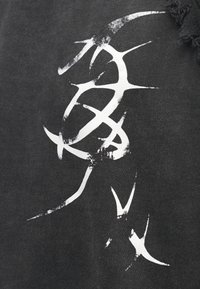 T-shirt de tecido preto com estampa gráfica abstrata branca. Bordas ligeiramente desgastadas e textura suave. Sem etiquetas ou marcas visíveis.