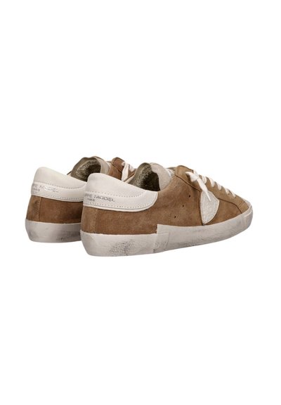 Sneaker in suede marrone con dettagli bianchi, lacci piatti, punta rotonda e suola leggermente consumata. Presenta il logo sul tallone e sul lato.
