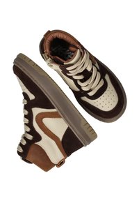 Bruine en beige hoge sneakers met dikke crèmekleurige veters en getextureerde panelen, gepositioneerd met één schoen die de zool toont en de andere de bovenkant.