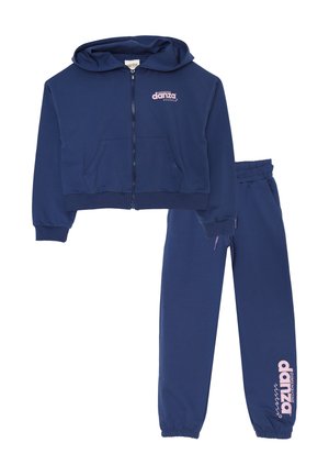 Completo tuta blu navy composto da giacca con cappuccio e zip, dotata di tasche frontali, e pantaloni coordinati con vita elastica e dettagli logo.