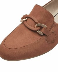 Brown suede loafer with a textured finish, featuring a prominent brown oval hardware accent and silver detailing, rounded toe design.