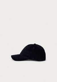 Svart kordfløyels baseballcap med subtilt brodert logo på forsiden, vist mot en enkel hvit bakgrunn.