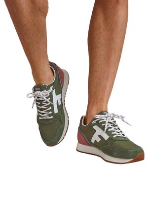 Grüne Sportschuhe mit weißen Akzenten, ausgestattet mit einem strukturierten Wildleder- und Mesh-Obermaterial, runder Zehenpartie und weißen Schnürsenkeln auf einer kontrastierenden Sohle.