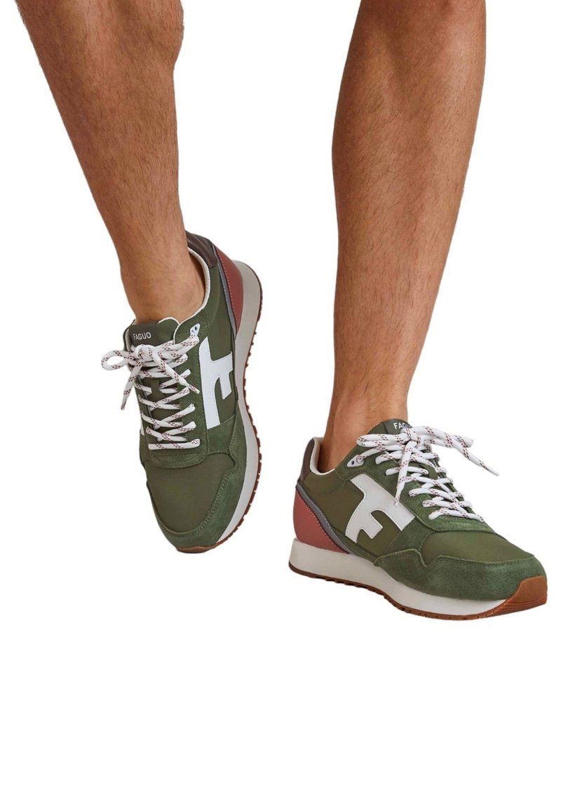 Green athletic shoes with white accents, featuring a textured suede and mesh upper, round toe, and white laces against a contrasting sole.