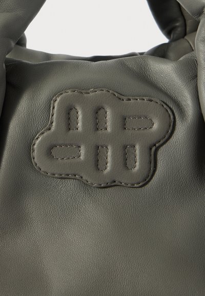  oliwkowa skórzana torba z teksturowanym logo z metalowymi detalami, przeszytymi wykończeniami oraz miękką, trójwymiarową formą.
