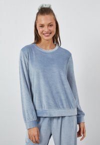 Jasnoniebieska bluza crew-neck z ribbowymi mankietami i dołem, wykonana z miękkiej, teksturowanej tkaniny, o luźnym kroju i długich rękawach.