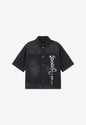 Camicia nera a maniche corte con bottoni e due tasche sul petto, con la scritta verticale bianca "ED HARDY 1971" sulla tasca destra.