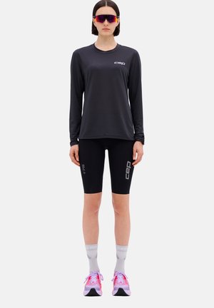 Black long-sleeve athletic shirt, black compression shorts, gray socks, pink and gray running shoes. CEP logo on shirt and shorts.