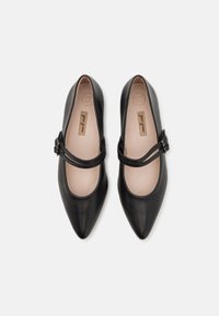 Ballerine in pelle nera con punta affusolata, dotate di due cinturini regolabili sul dorso del piede e di una morbida fodera interna.