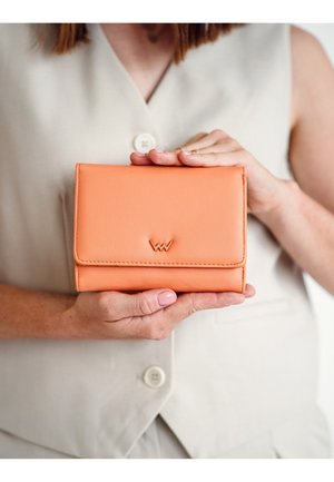 Orange leather wallet with a textured surface, featuring a front flap, stitched edges, and a logo emblem on the front.