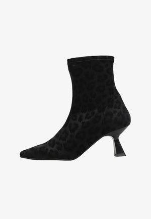 Botines de tela negra hasta el tobillo con un patrón de print de leopardo, punta afilada y un tacón bajo y ancho. Textura suave con un diseño sin costuras.