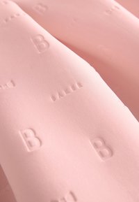 Rosa Stoff mit glatter Textur, der geprägte Buchstaben und Muster aufweist, darunter wiederholte Designs von "B" und "BALL".