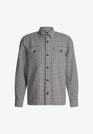 Camicia a quadri nei toni del blu navy e beige, realizzata in tessuto strutturato. Presenta un colletto, maniche lunghe, due tasche sul petto e chiusura con bottoni.