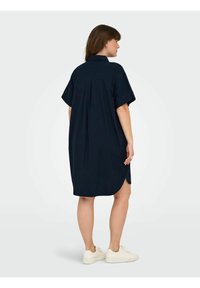 Roșie marină, rochie camdrenă cu guler, mâneci scurte, fante laterale și o croială lejeră, fabricată dintr-un material ușor. Purtați cu adidași albi.
